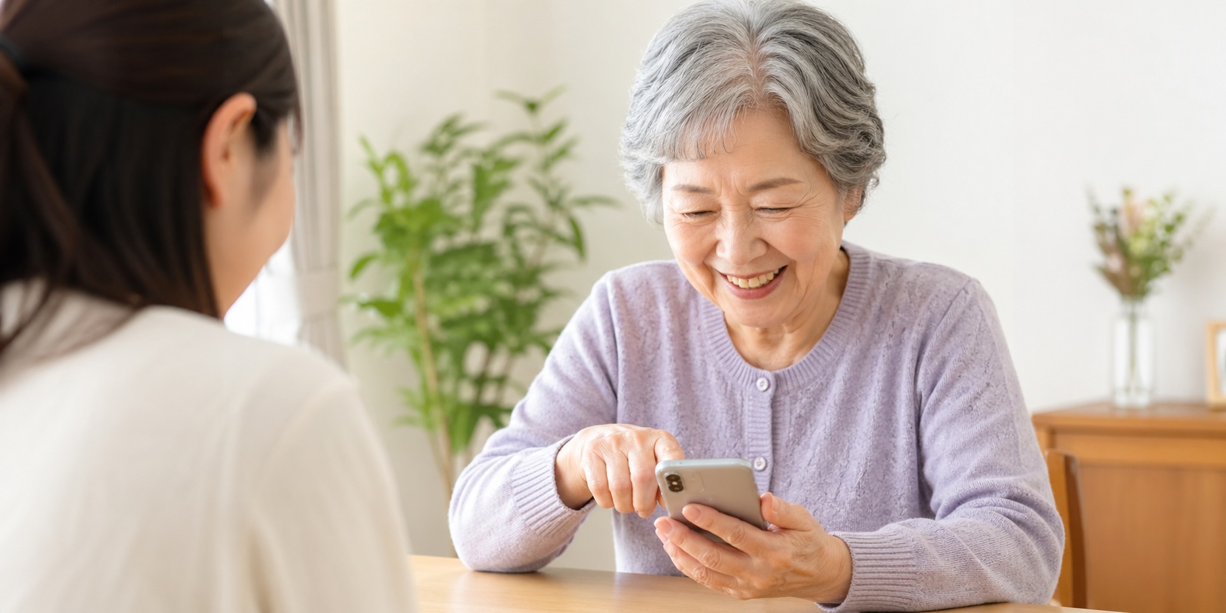スマホを楽しむご高齢の女性と、お話を聞く相談員
